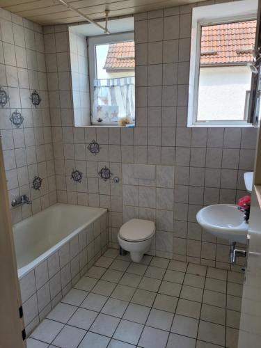 a bathroom with a tub and a toilet and a sink at Simple Übernachtungsmöglichkeit in Krumbach
