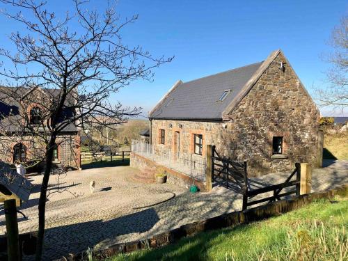 an old stone barn with a fence in front of it at Countryside Cottage in Ardee