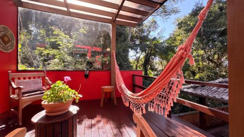 a hammock on the deck of a house at Pousada Vila Taquaras in Balneário Camboriú