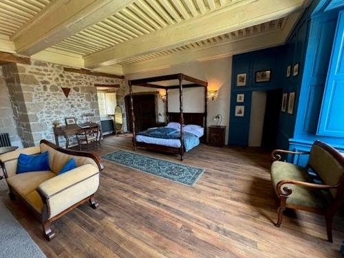 a living room with a bed and a couch at Lieu dit La Chassagne in Saint-Hilaire-le-Château