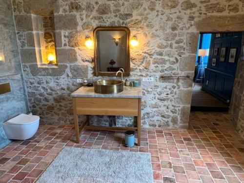 a stone bathroom with a sink and a toilet at Lieu dit La Chassagne in Saint-Hilaire-le-Château