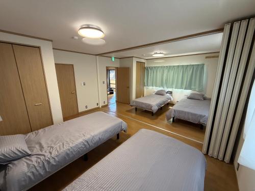 a hospital room with two beds and a window at Guest House Masaru ゲストハウス勝 in Nagano