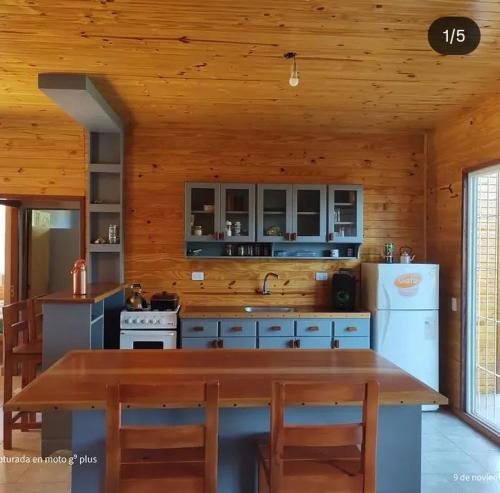 a kitchen with a table and a refrigerator at Quinta Bommerl in Paso de la Patria