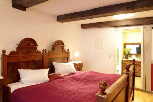 a bedroom with a large bed with a red blanket at Fleischhauerhof in Lübeck
