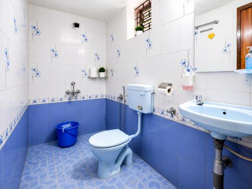 a blue and white bathroom with a toilet and a sink at Royalstar Resort in Vagator