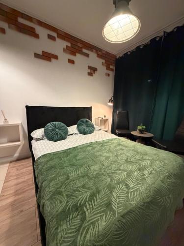 a bedroom with a green bed with two pillows on it at Cicha Przystań w Centrum -Mała Sienkiewicza in Kielce