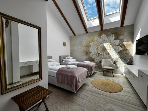 a bedroom with two beds and a painting on the wall at Rancho Lawendowe in Szczytna
