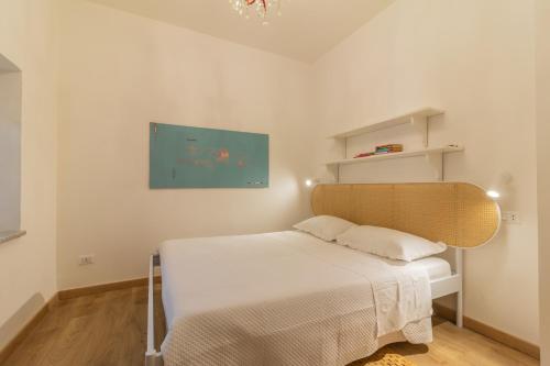 a bedroom with a bed and a painting on the wall at PianoPiano Nel cuore del borgo di Viterbo P1 in Viterbo