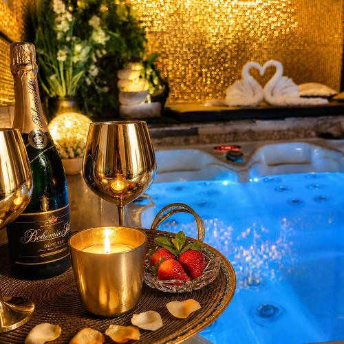 a table with a bottle of wine and a candle and strawberries at Sofia Private Wellness Apartman Prague - Sauna & Jacuzzi in Prague