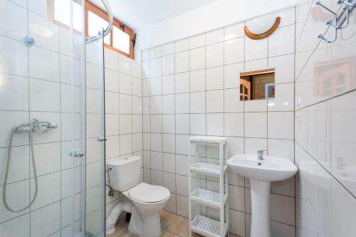 a white bathroom with a toilet and a sink at Domki na Wyspie Anna in Gdańsk