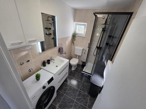 a bathroom with a white sink and a shower at UP & DOWN Holiday House in Donji Prozor