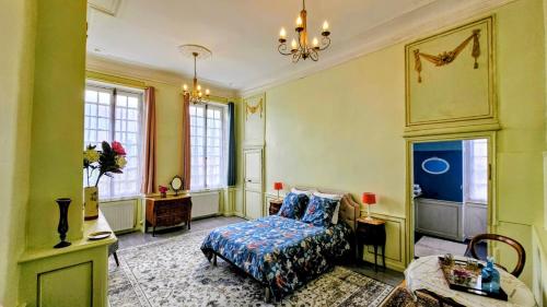 a bedroom with a bed and a table and windows at Château Arche d'Aure in Vicq-dʼAuribat