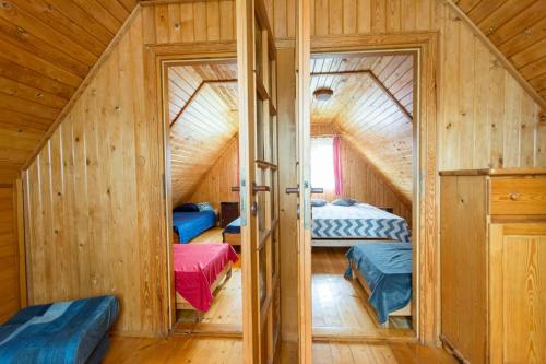 a room with two beds in a wooden house at Domki na Wyspie Anna in Gdańsk