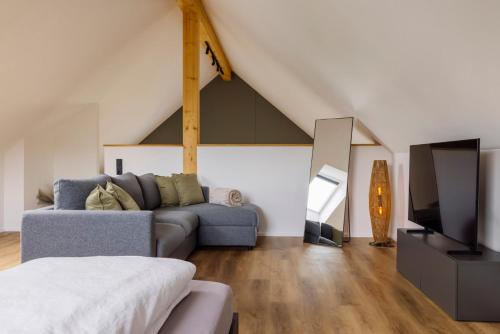 a living room with a couch and a tv at Traumnest Eifel mit Sauna & Whirlpool in Monschau