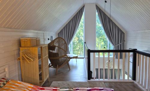 a room with a bed and a chair and windows at Las Tu Las Tam in Chudaczewko