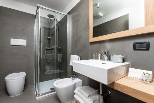 a bathroom with a sink and a shower and a toilet at Hotel Orso Grigio in Selva di Cadore