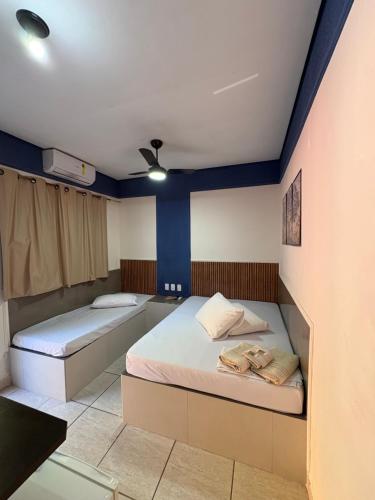 two beds in a room with blue walls at Pousada Caminhos do Interior in Sorocaba