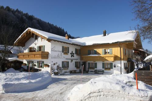 a large building with snow on the ground at Pension Gimpl, Chiemgaukarte neu in Siegsdorf