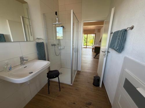 a white bathroom with a sink and a shower at Ferienhaus im Günztal in Lauben