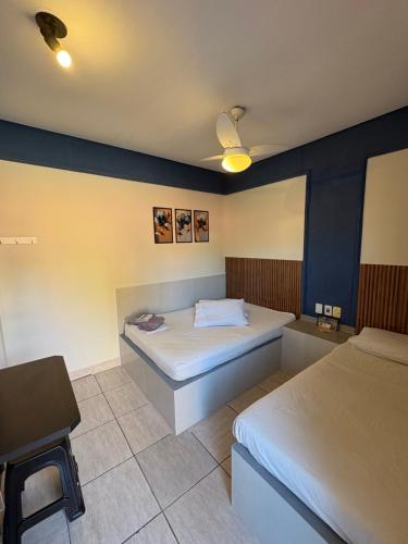 a bedroom with two beds and a chair in it at Pousada Caminhos do Interior in Sorocaba