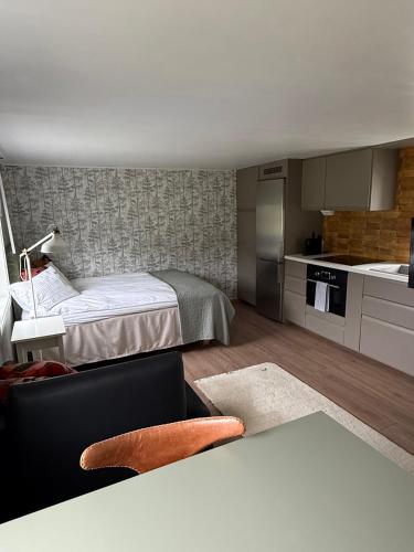 ein kleines Zimmer mit einem Bett und einer Küche in der Unterkunft Lantligt läge nära golfbana in Västerås