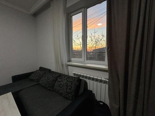 a living room with a couch and a window at Relax garden area with BBQ zone in Yerevan