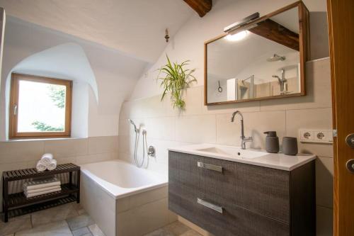 ein Badezimmer mit Waschbecken, Badewanne und Spiegel in der Unterkunft Saxöler Brixen in Brixen