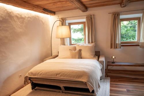 ein Schlafzimmer mit einem Bett, einer Lampe und zwei Fenstern in der Unterkunft Saxöler Brixen in Brixen