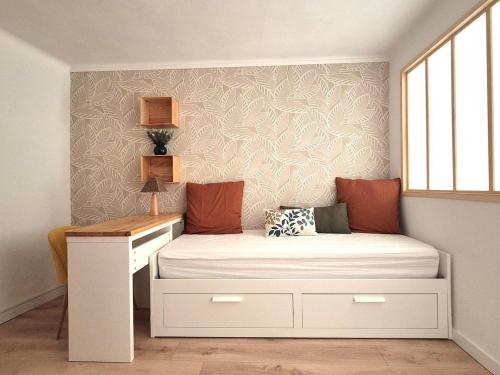 a small bedroom with a bed and a desk at Maison des Arches in Barbentane