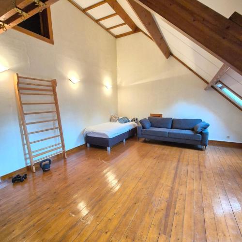 a living room with a blue couch and a ladder at Spacious manor house with pool & playground in Essen