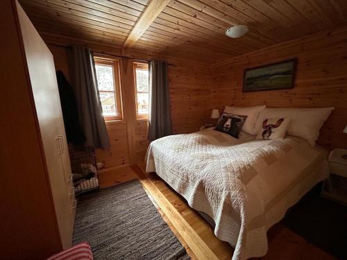 a bedroom with a bed in a log cabin at Lyngbu på Stavtjørn in Vikeså