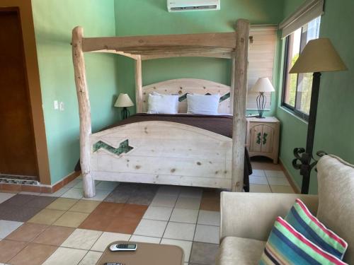 a bedroom with a wooden bed in a green room at Loreto Playa Boutique Hotel in Loreto