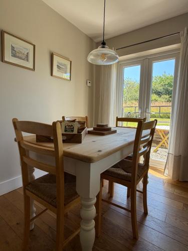 a dining room with a table and chairs and a window at The Old Tearooms in Rural Northumberland in Edlingham