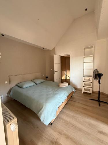 a bedroom with a large bed and a fan at Gîte du silo Avoine in Toucy