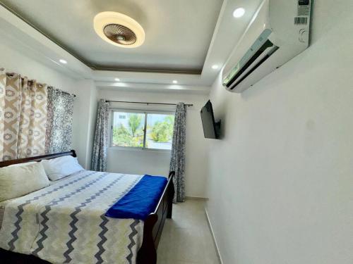 a bedroom with a bed and a window at Tepuy Residential in Juan Dolio