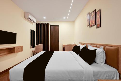 a hotel room with a bed and a television at Hotel O Grand Shivay in Indore