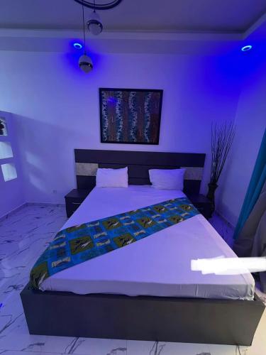 ein Schlafzimmer mit einem großen Bett und violetter Beleuchtung in der Unterkunft Studio in Saly Portudal