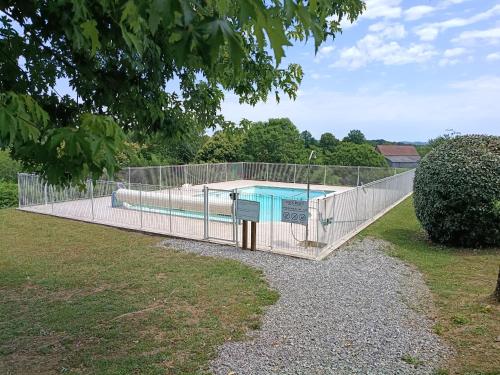 a swimming pool with a fence around it at Charmante maison avec jacuzzi privatif in Saint-Salvadour