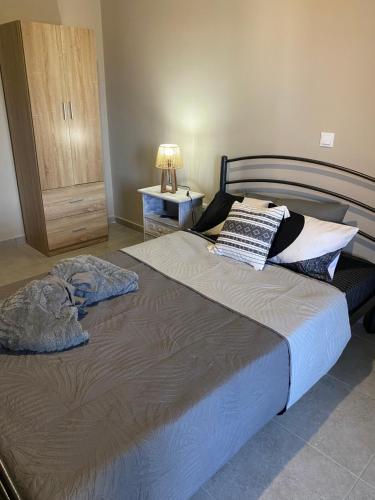 a bedroom with a large bed with two pillows on it at Villa J&C-SAINT AIMILIANOS in Porto Heli