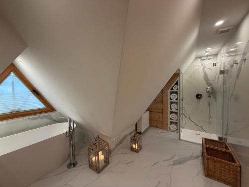 a attic bathroom with a shower and a walk in shower at Tatra Whisper Chalet in Ząb