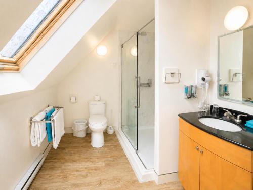 a bathroom with a shower and a toilet and a sink at Rum Runner Inn in Lunenburg