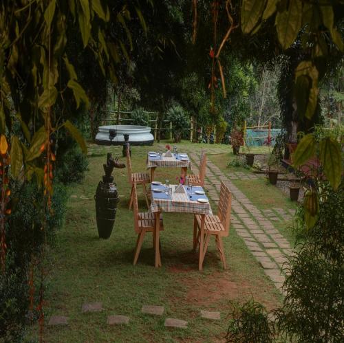 a table and chairs with a surfboard on top of it at Dew Drops Farm Resorts in Munnar