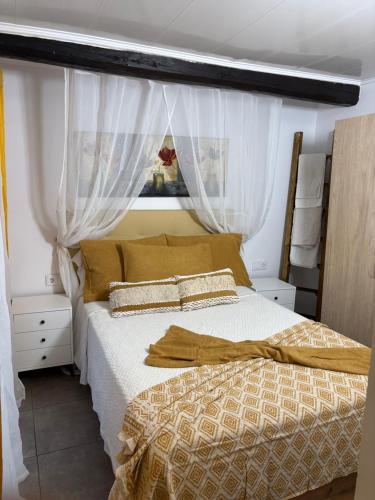 a bedroom with a bed with a canopy and curtains at El renacer de Flor - Casa turística in Chandreja