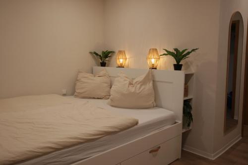 ein Schlafzimmer mit einem Bett, auf dem zwei Lampen hängen in der Unterkunft Ritterschlaf in Balingen