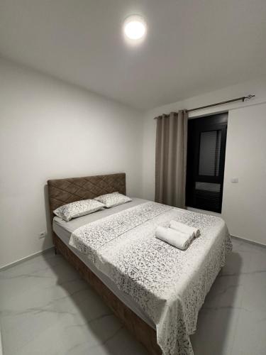 a bedroom with a bed with two towels on it at Apartments Aroma in Tomba