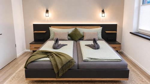 a large bed with two pillows on top of it at Barrierefreie Ferienwohnung Abendrot in Pewsum, 1 - 4 Personen in Krummhörn