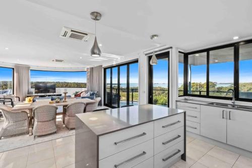 a kitchen with white cabinets and a table with chairs at Seabreeze Sanctuary in Long Beach