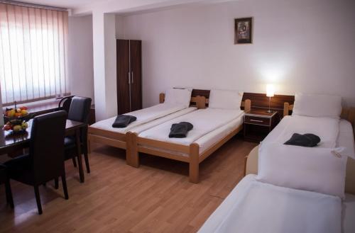 a hotel room with two beds and a table and a desk at Modex Apartments in Paraćin