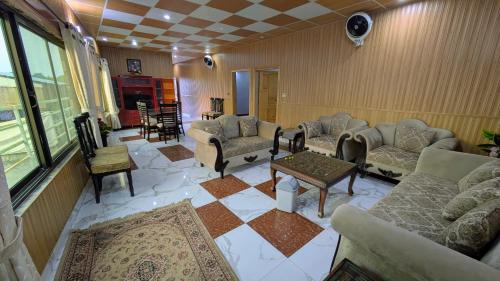 a living room with couches and chairs and a table at Afridi Apartment in Murree