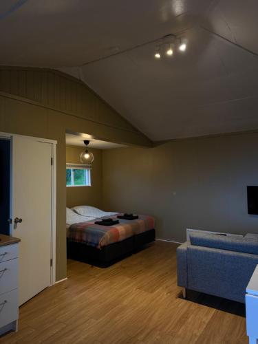 a bedroom with a bed and a couch at Krókur Guesthouse in Patreksfjörður